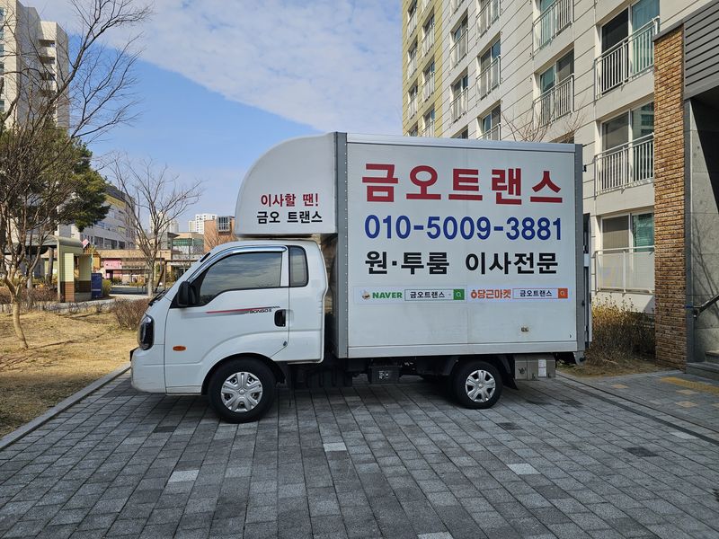 아파트 단지에 세운 금오트랜스 흰색 1톤 탑차 옆모습
